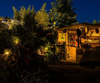 The lights at night on The Fauna & Flora Garden designed by Jilayne Rickards at the 2023 RHS Chelsea Flower Show