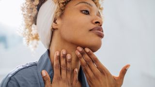 Woman looking in the mirror and touching her face