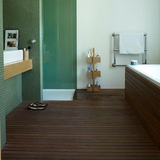 bathroom with wooden floor and green tiles and footwear