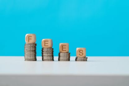 Word fees on stack of coins.