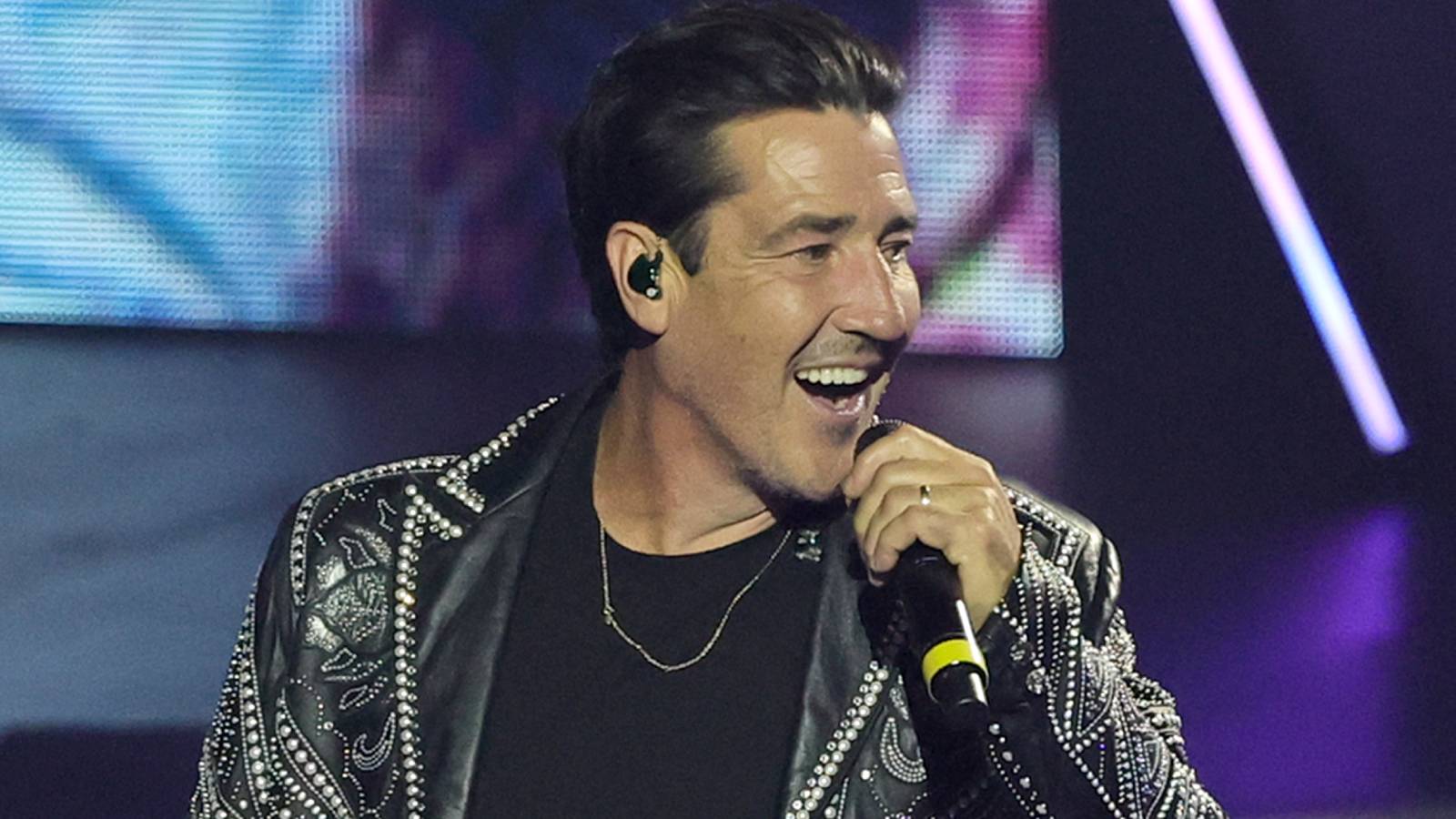Jonathan Knight of New Kids on the Block singing into a microphone