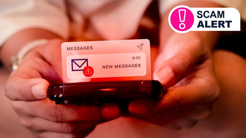 Two hands holding a phone in red lighting showing a scam text message