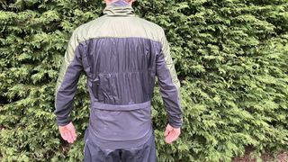 Rear view of rider wearing Castelli Unlimited Puffy gravel Jacket