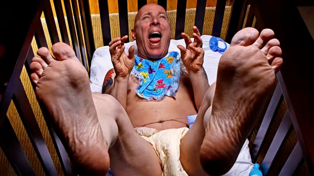 Maynard James Keenan dressed as a baby in a crib