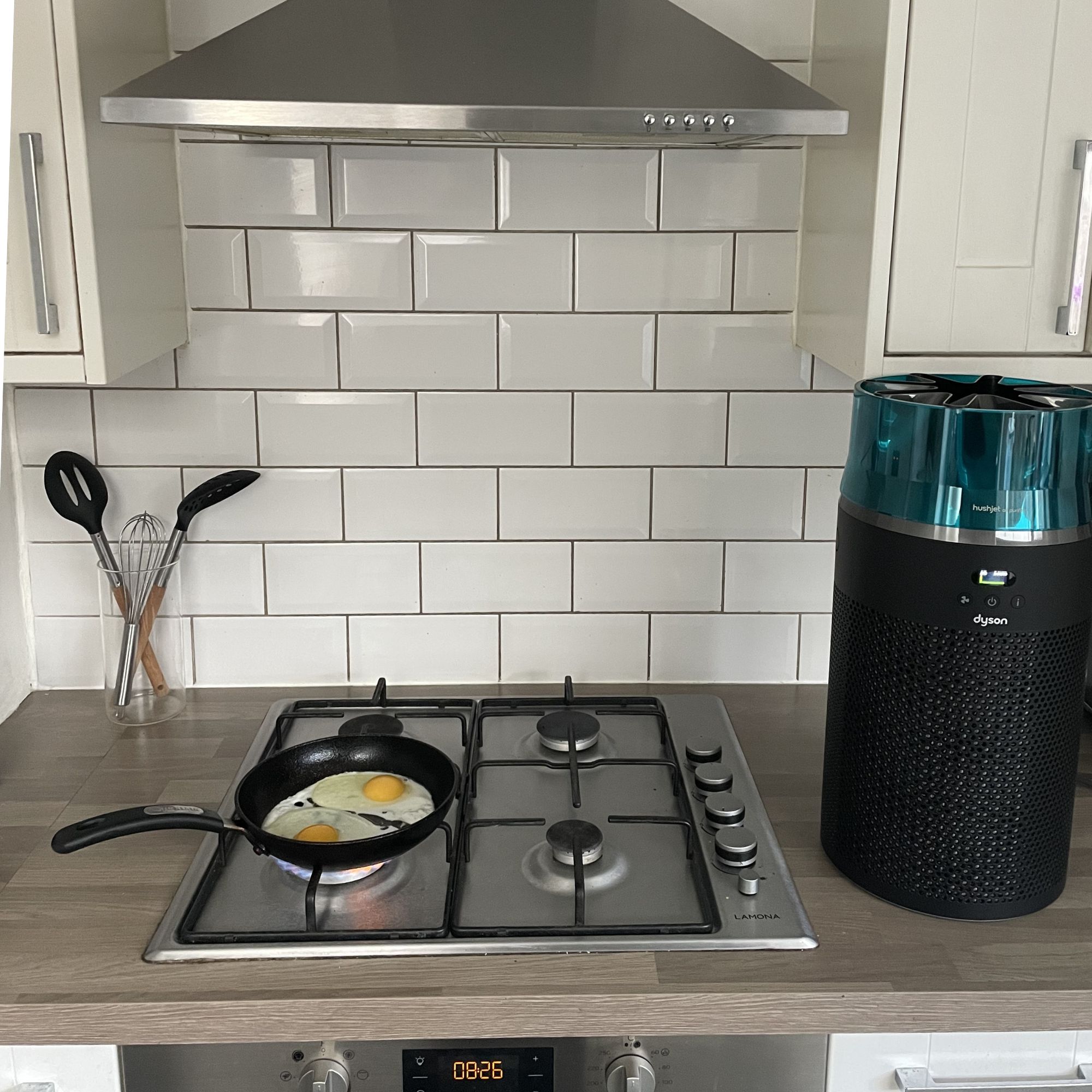 Dyson Hushjet Air Purifier sitting on kitchen worktops, next to a gas hob with two eggs in a frying pan