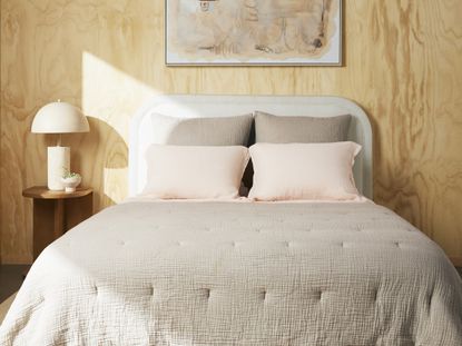 A bedroom with a beige cotton quilt