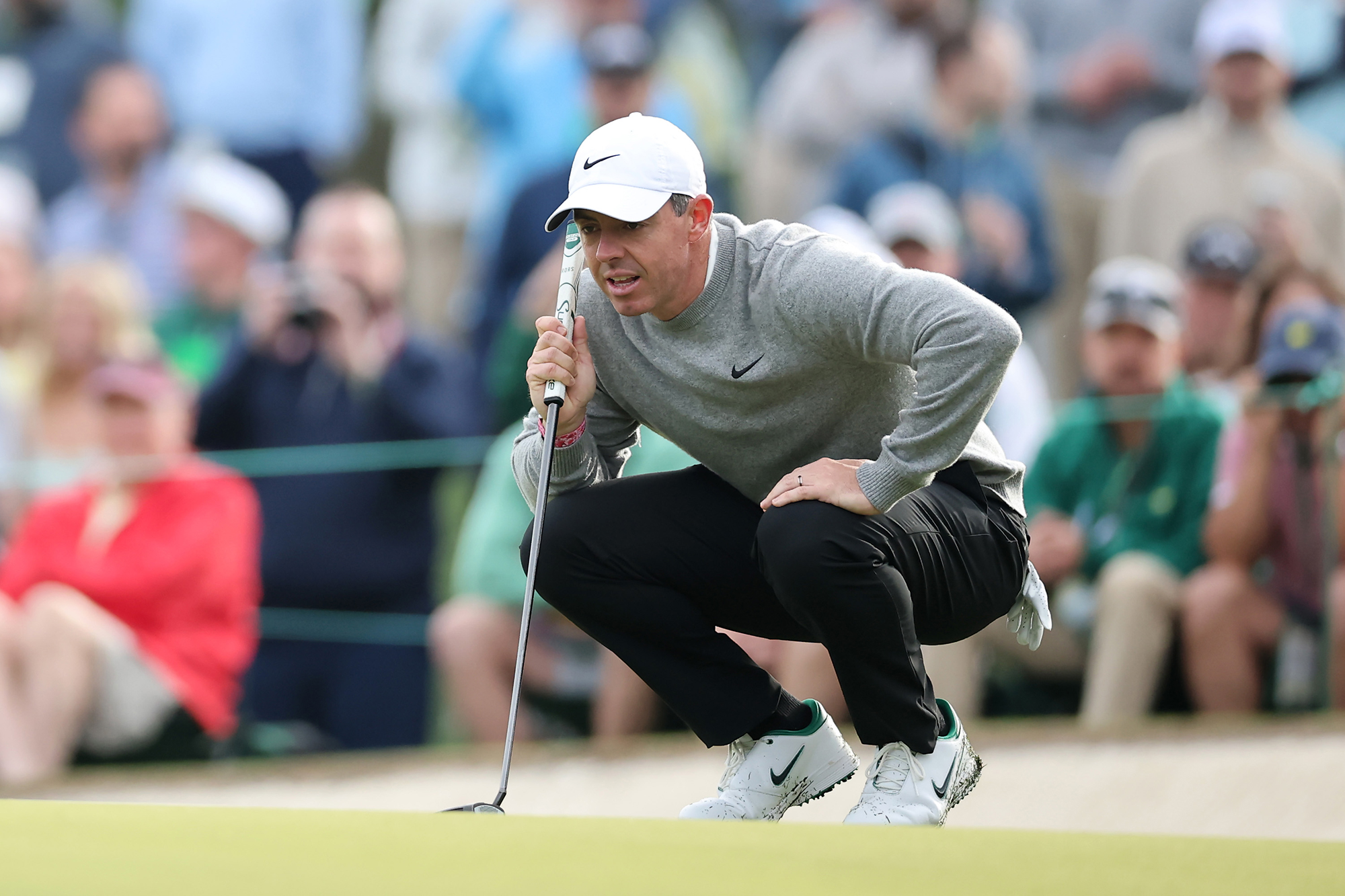 Rory McIlroy reading a putt at Augusta National during a practice round at the Masters
