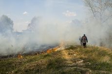 Firefighters breathe in smoke from a wildfire.