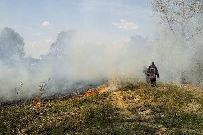 Firefighters breathe in smoke from a wildfire.