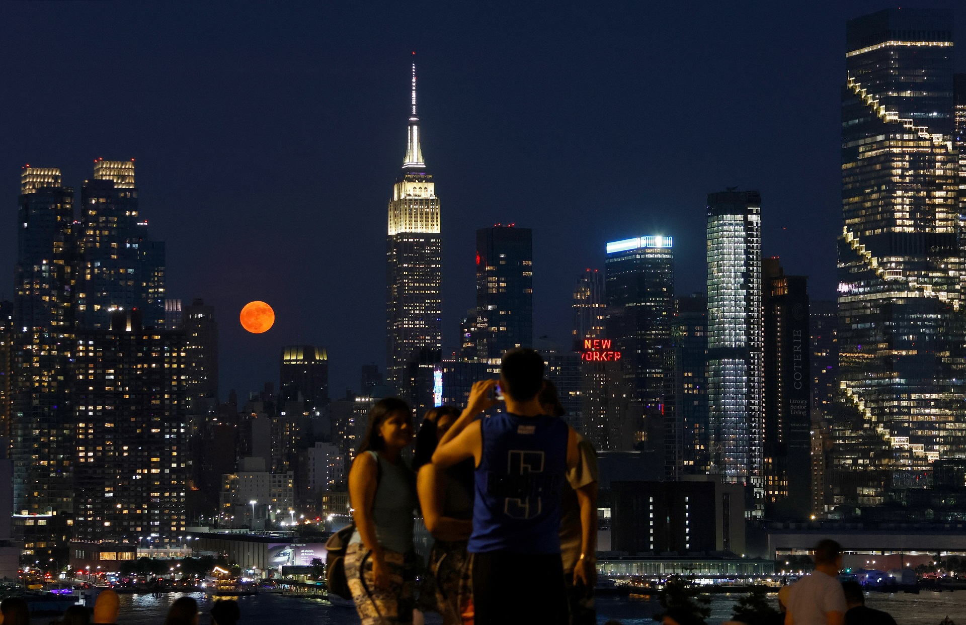The full Strawberry Moon rises behind the Empire State Building in New York City on June 21, 2024, as seen from Weehawken, New Jersey.