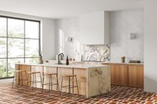 A kitchen with terracotta style tiles on the floor and white textured gloss tiles up the sink wall