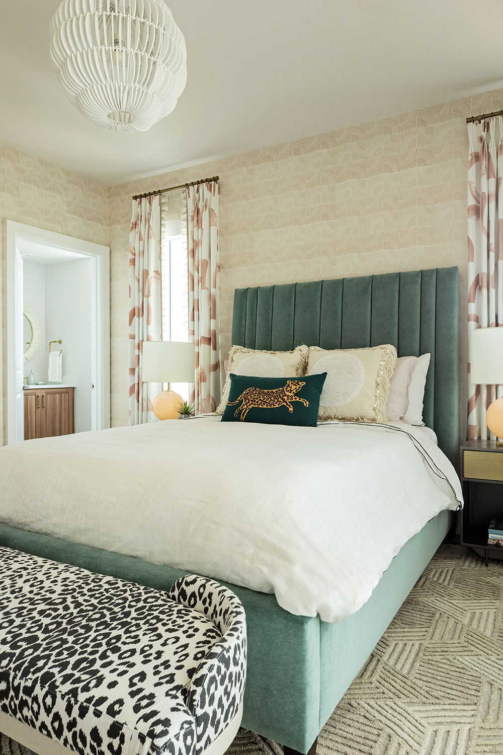 spare bedroom with blue velvet headboard and animal print footstool