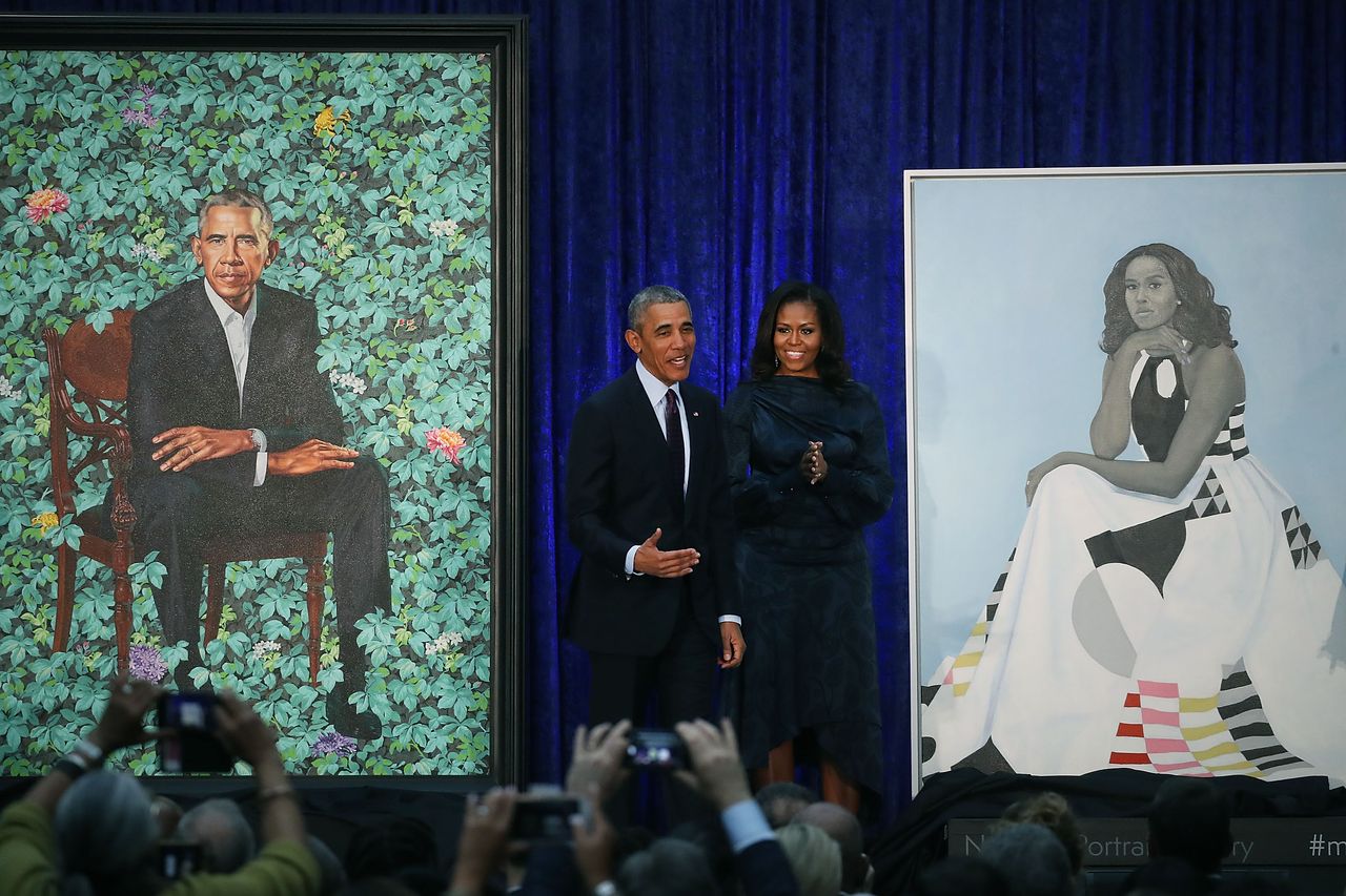 Barack and Michelle Obama stand by their portraits