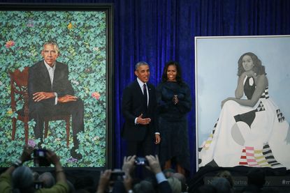 Barack and Michelle Obama stand by their portraits