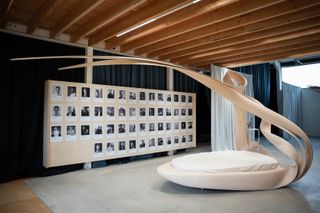 sculptural wood furnishing and a board covered in portraits