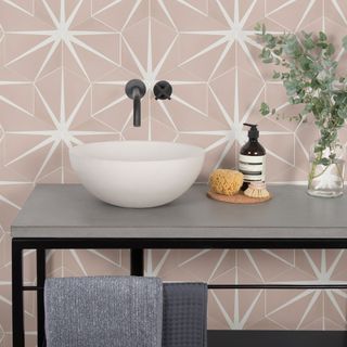 Pink bathroom with tiled walls and matt black furniture