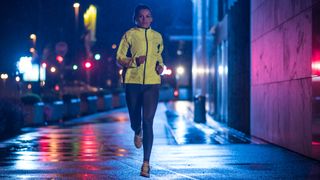 a photo of a woman running through the streets wearing a high vis jacket