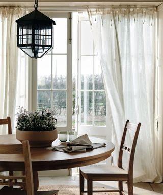 A dining room table in front of a floor to ceiling window