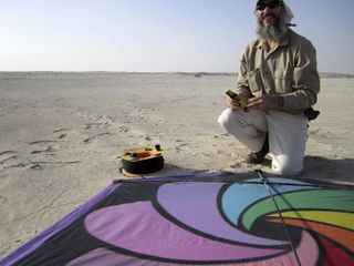 Nathan Craig preparing a kite for low-altitude photography of the elephant trackway site. The researchers mounted a pocket digital camera onto the kite, stitching the hundreds of pictures it took into a single large mosaic image that gave a broad overview