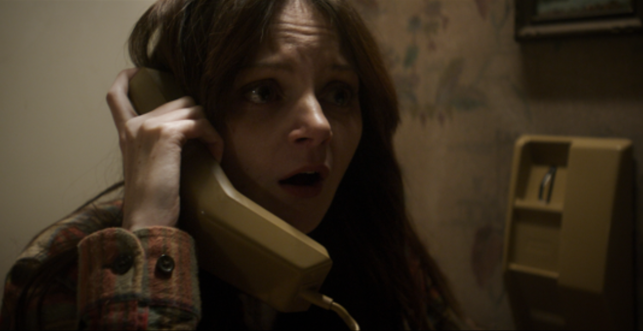 A woman is on the phone and looks worried