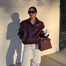 Aimee Song in a burgundy leather bomber jacket and matching Hermés bag.