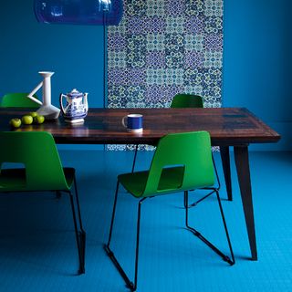 blue dining room with dining table and green chairs