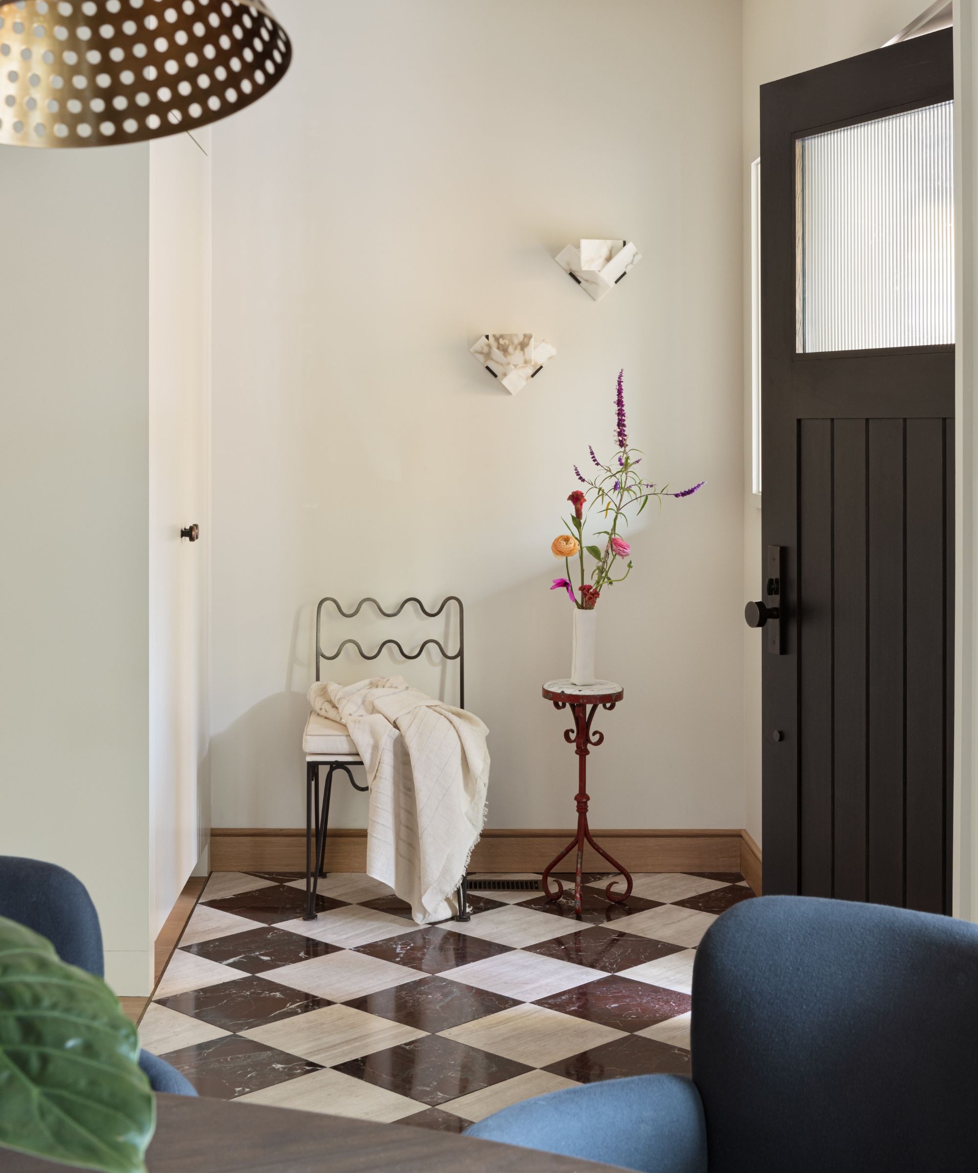 Entry hallway with brown and white checkerboard marble flooring and minimal furnishings.