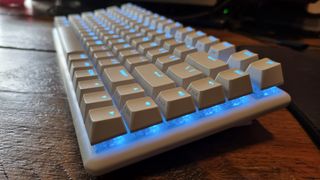 The Alienware Pro Wireless Gaming Keyboard, at an angle, lit up in blue