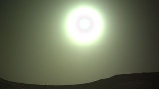 An overexposed sun shines on Mars with a round circle inside it.