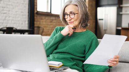 A woman looks at a computer screen very thoughtfully.