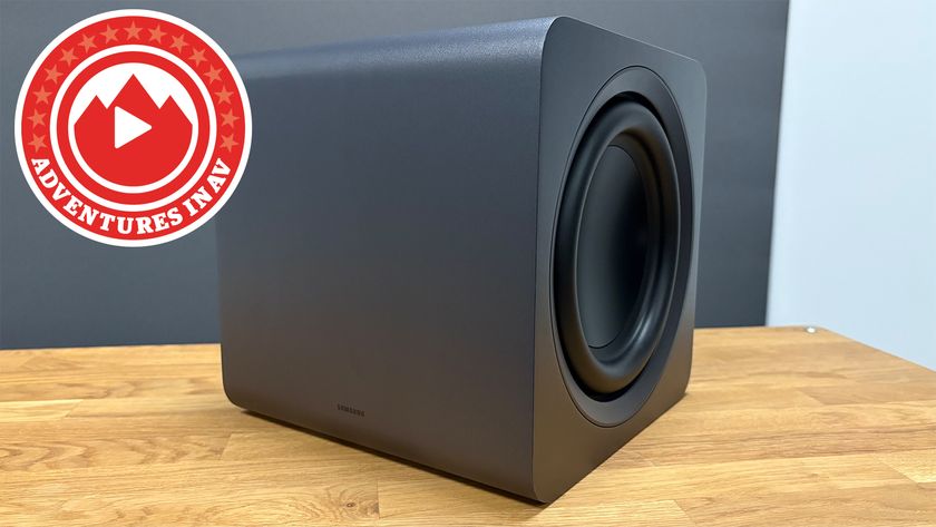 A Samsung wireless subwoofer on a wooden tablet with a logo that reads "Adventures in AV"