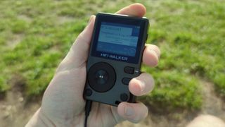 The HiFi Walker H2 in a man's hand.