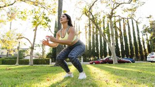 Woman practicing jump squats in a park