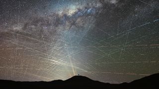 bright streaks of light crisscross through a night sky