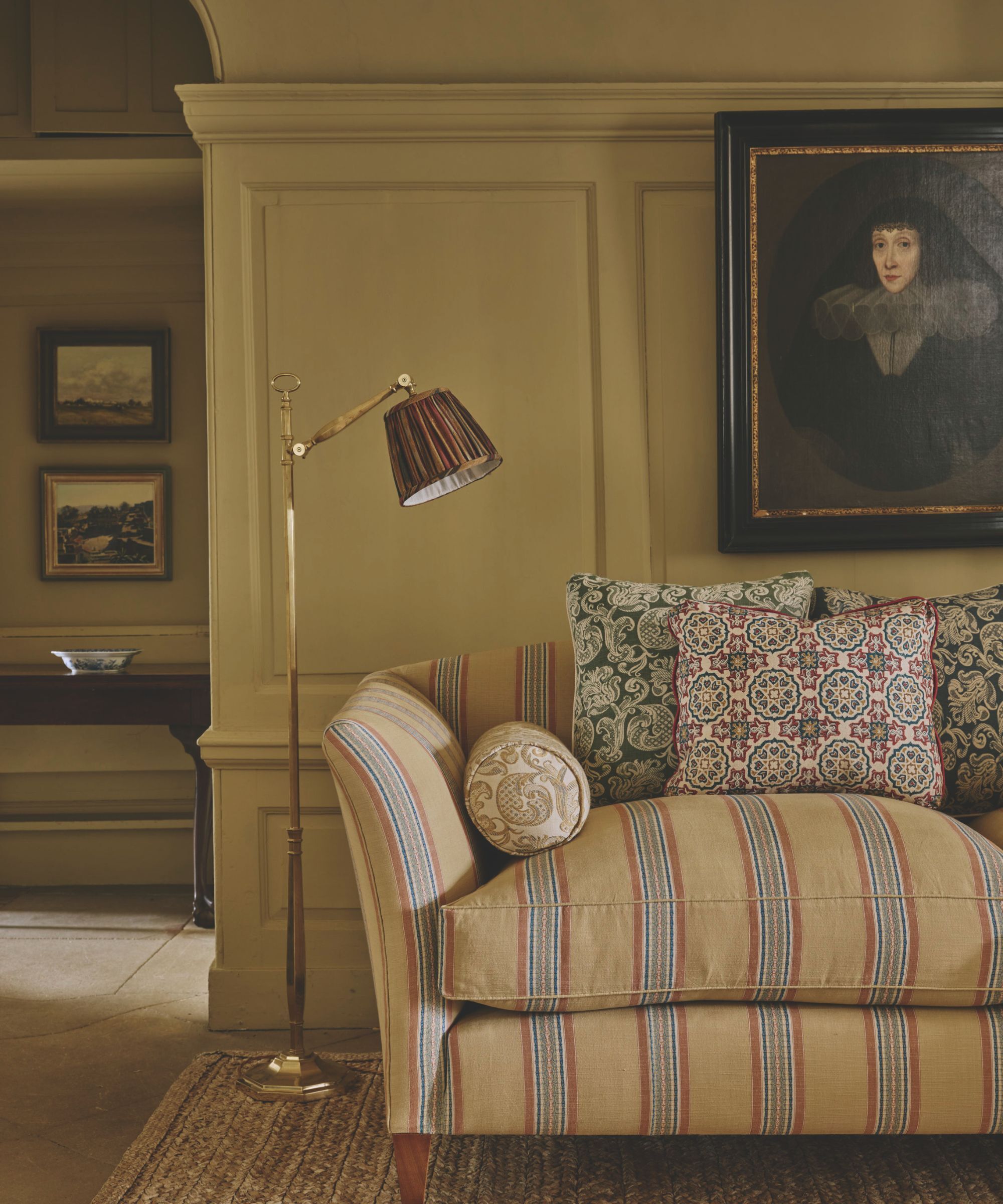 Traditional sitting room with striped sofa and butter yellow panelled walls