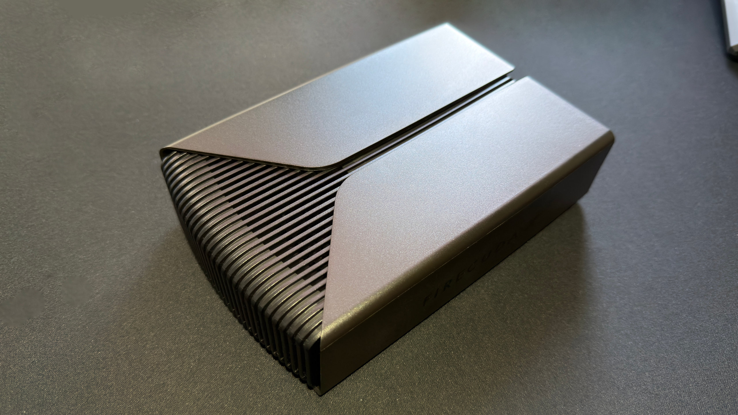 A photo of a Seagate FireCuda X Vault external hdd, resting on a computer desk