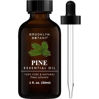 A brown bottle of pine essential oil with a black lid and pipette