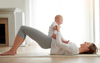 Mum doing postnatal exercise with baby on her stomach