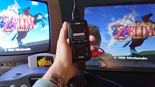 Hand holding HDMI scanline generator with an N64 hooked up to input that is connected to a Philips CRT on the left and a portable monitor on the right.