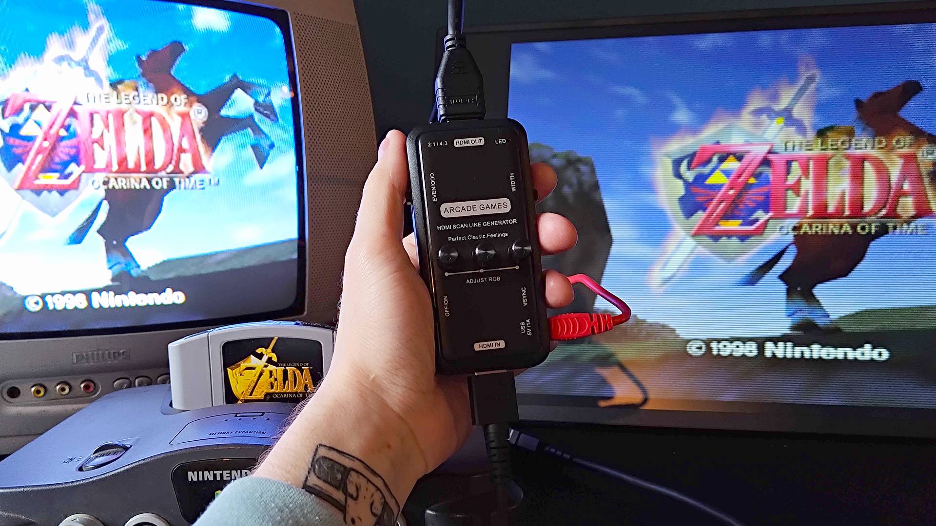 Hand holding HDMI scanline generator with an N64 hooked up to input that is connected to a Philips CRT on the left and a portable monitor on the right.