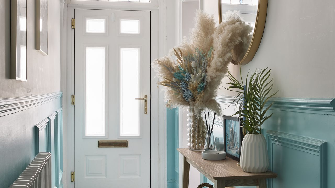 Hallway with white front door and blue panelling