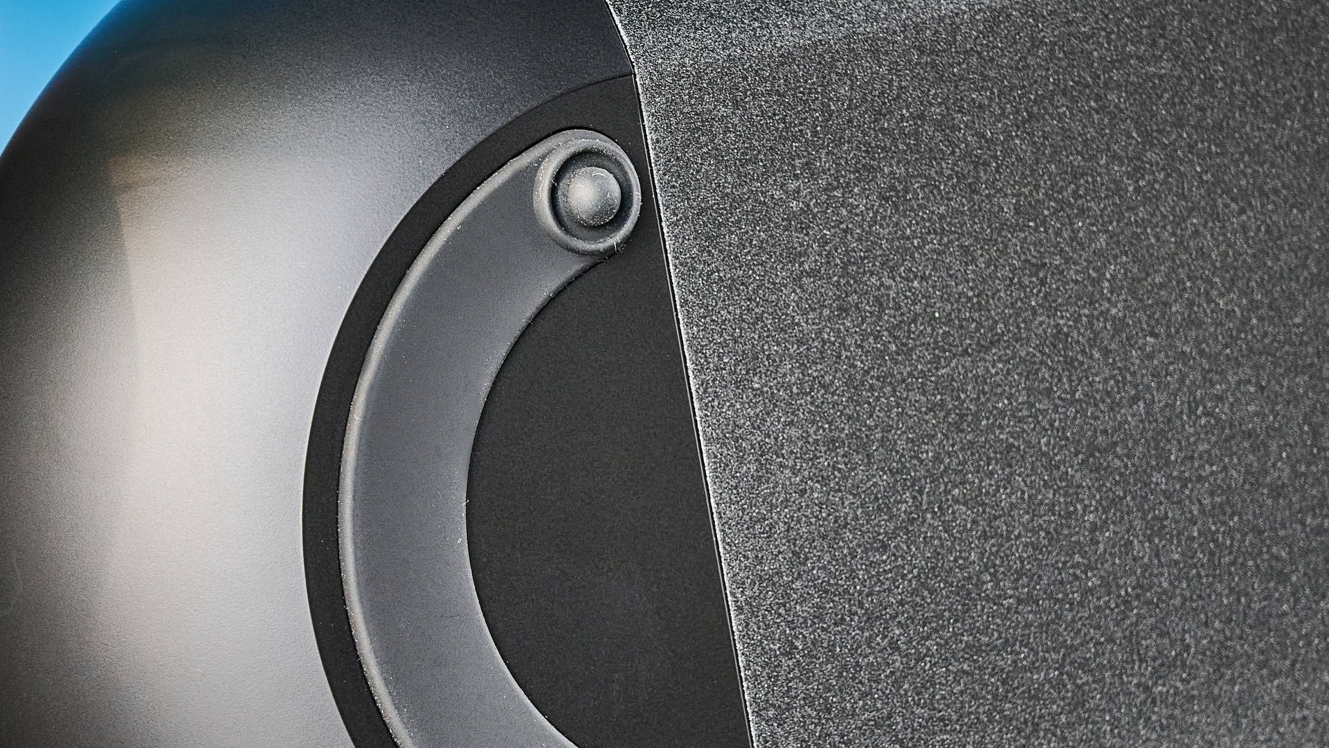 the bluesound pulse cinema soundbar photographed with a TV and the tom's guide blue background