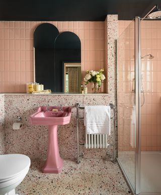 A bathroom with a retro pink sink