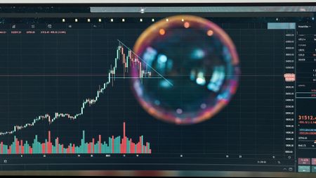 Image of a bubble over a falling stock market graph.