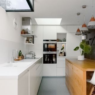 white kitchen timber kitchen island oven plants skylights