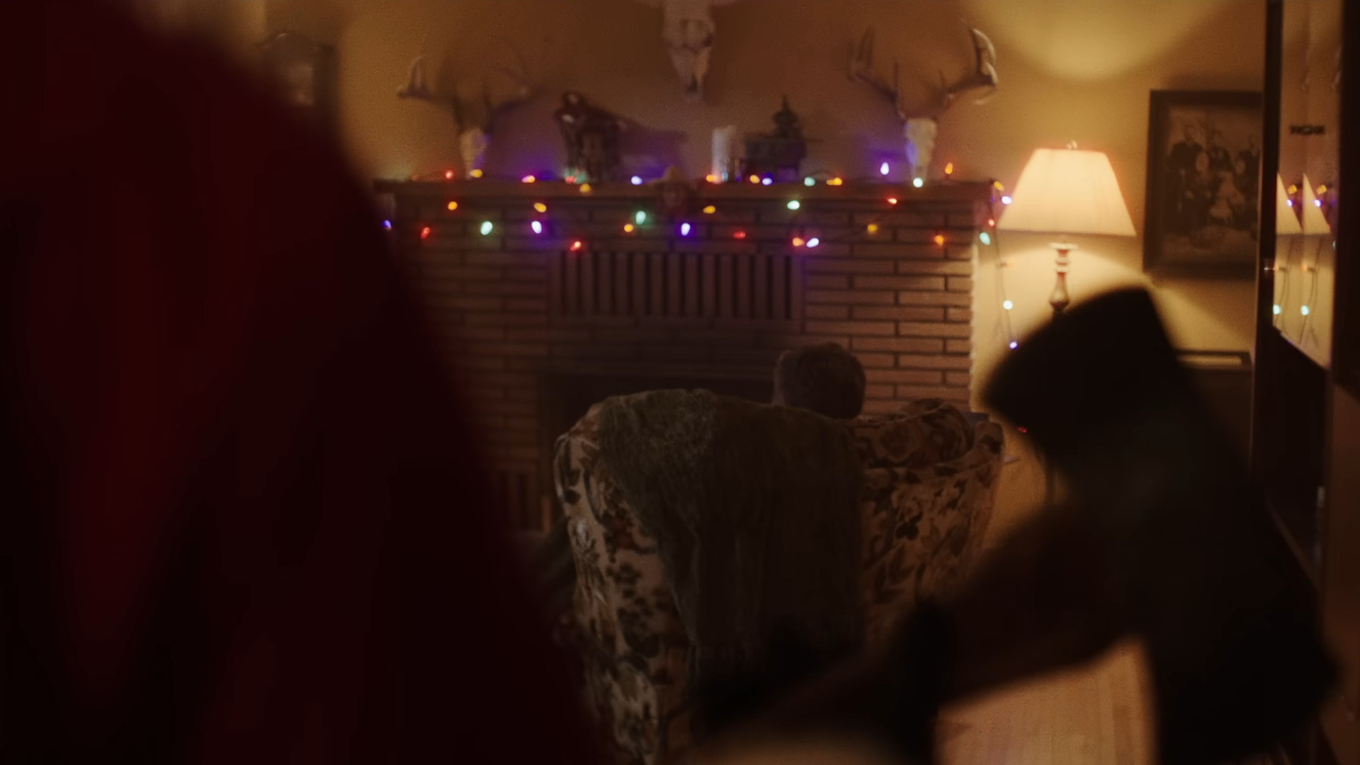 A screenshot of a man holding an axe and stalking towards a man in a chair during the upcoming movie, Silent Night, Deadly Night.