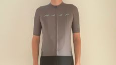 Male cyclist wearing the Maap Pro Evade Base Jersey 2.0 in gargoyle grey