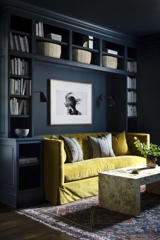 dark blue living room with wrap around built in storage and bright yellow sofa