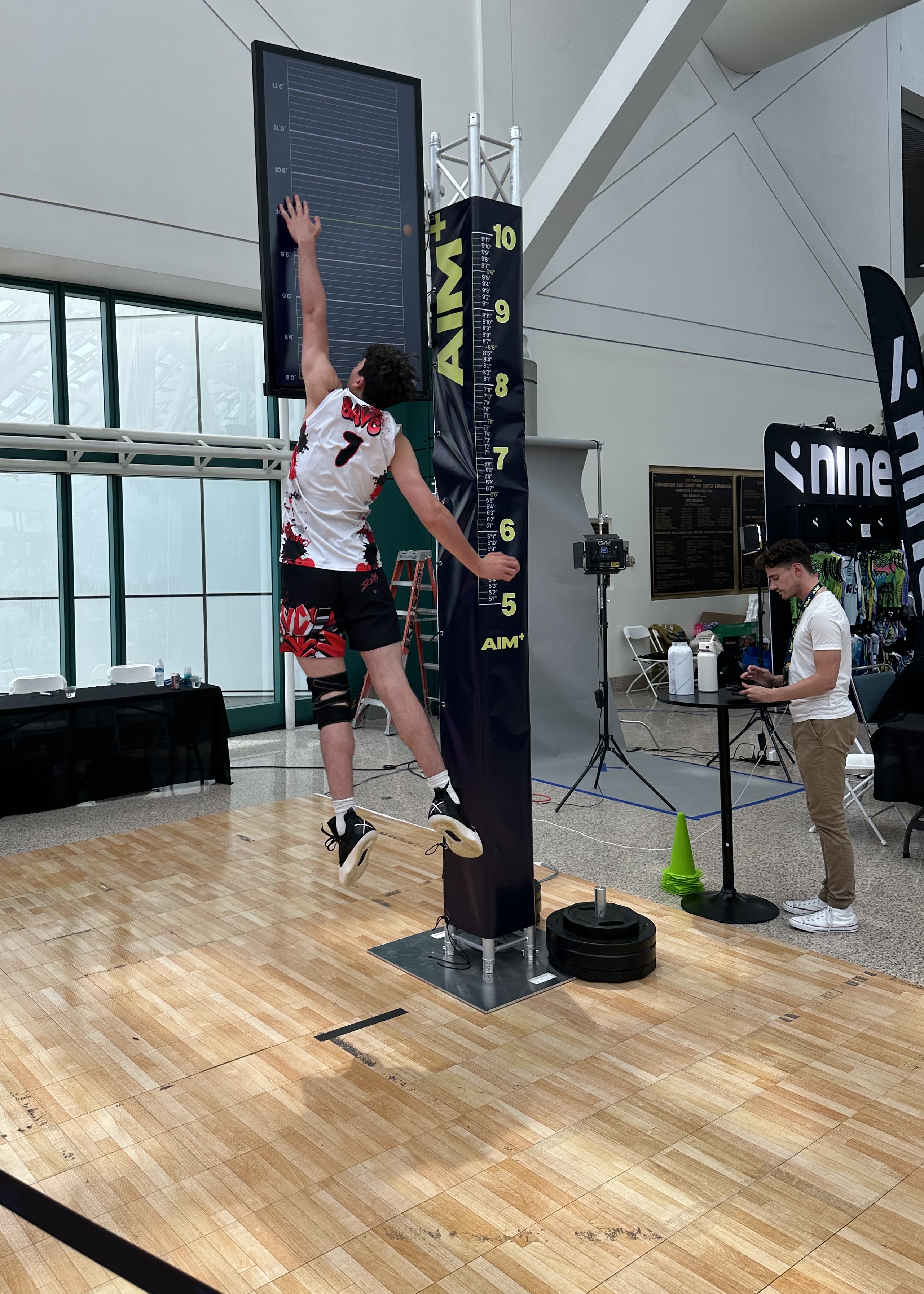 A basketball player doing a vertical jump against a digital signage marker.