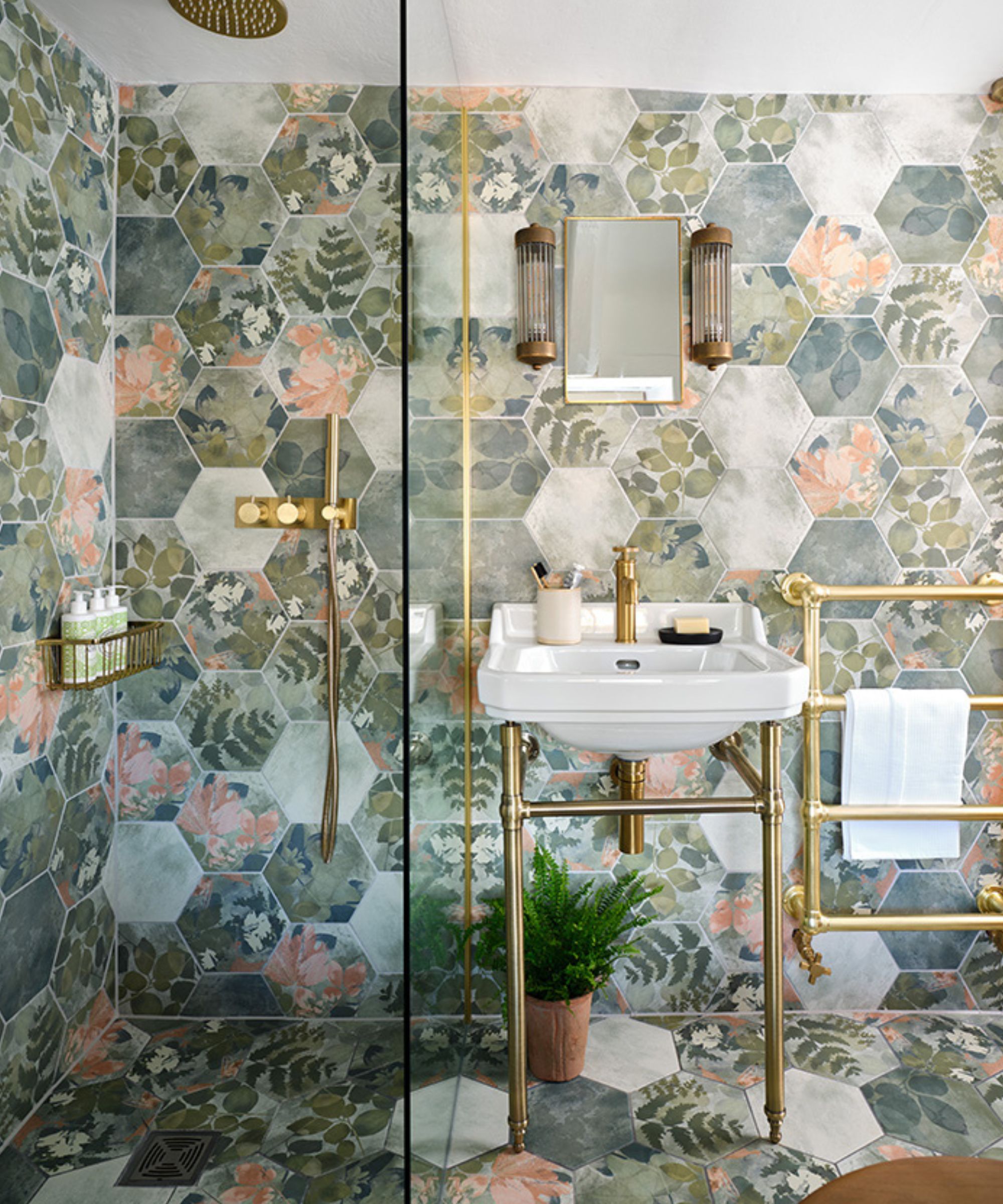 Patterned hexagon tiles in botanical print wet room with brass fittings